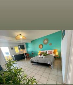 um quarto com uma cama e uma parede azul em Appartement les pieds dans l'eau em Sainte-Anne