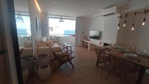 een woonkamer met een tafel en een woonkamer met een bank bij El balcon de formentera in La Savina