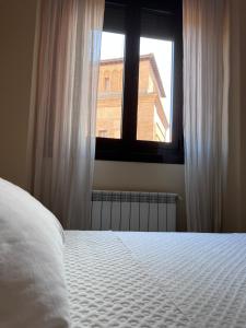 1 dormitorio con cama blanca y ventana en Apartment in monumental square Madrid Center, en Madrid