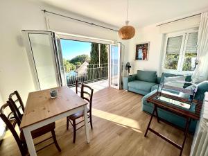 Una sala de estar con una mesa y un sofá azul. en La casa alle Calandre, en Ventimiglia