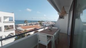 balcón con mesa, sillas y vistas al océano en El balcon de formentera en La Savina