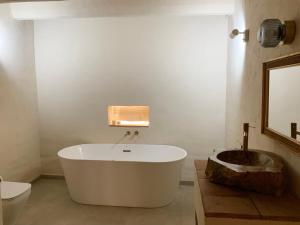 El baño incluye bañera blanca y aseo. en El Reposo de la Grulla, en Perales del Puerto