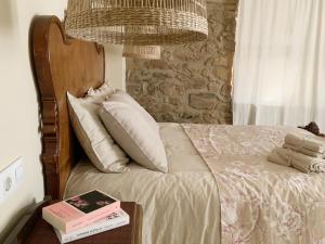 1 dormitorio con 1 cama con pared de piedra en El Reposo de la Grulla, en Perales del Puerto