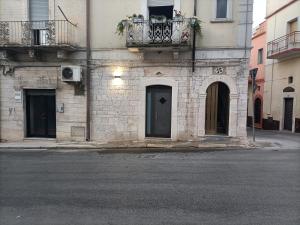 ein Backsteingebäude mit einer Tür und einem Balkon in der Unterkunft Il rifugio del folletto in Santeramo in Colle