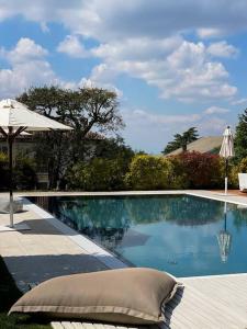 einen Pool mit einem Kissen und einem Sonnenschirm in der Unterkunft Casa Riviera by Corte Gondina in La Morra