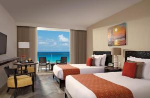 a hotel room with two beds and a view of the ocean at Krystal Grand Cancun All Inclusive in Cancún