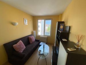 - un salon avec un canapé noir et une table en verre dans l'établissement Holidays apartment Bourgas, à Bourgas