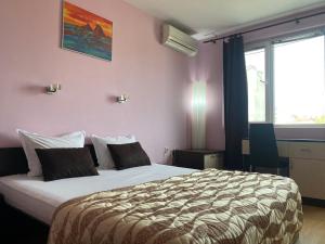 - une chambre avec un grand lit dans une pièce aux murs roses dans l'établissement Holidays apartment Bourgas, à Bourgas