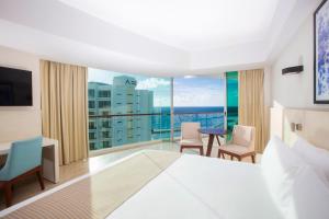 a hotel room with a bed and a large window at Krystal Grand Cancun All Inclusive in Cancún