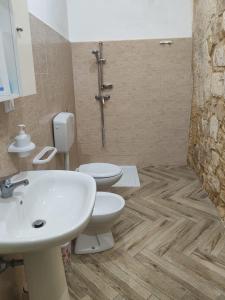 bagno con 2 servizi igienici, lavandino e doccia di Petra Barocca a Scicli