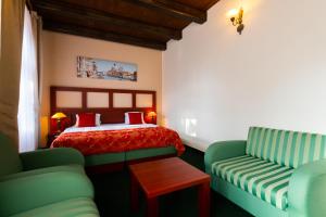 1 dormitorio con 1 cama y 2 sillas verdes en Vivaldi Apartments en Mikulov