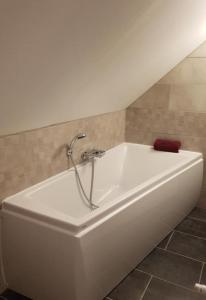 a white bath tub with a faucet in a bathroom at La longère Des Glycines in Égligny