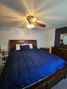 a bedroom with a blue bed with a ceiling fan at Saratoga Track Concert Season Moonfish Cabana weekly rentals in Saratoga Springs