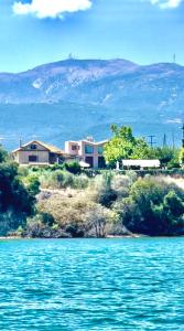 a house on a hill next to a body of water at Rouga Paradise Resort in Vonitsa