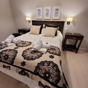 sypialnia z dużym łóżkiem i dwoma stołami w obiekcie TADASANA HOUSE w mieście Ushuaia