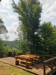 a wooden deck with a picnic table in the woods at Vikendica Čeperković #1 in Kopaonik
