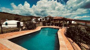 a swimming pool in front of a house at Hermoso Glamping Karpatos in Barichara