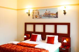 um quarto de hotel com uma cama com almofadas vermelhas em Vivaldi Apartments em Mikulov