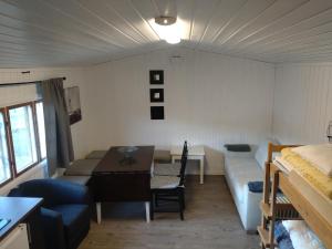 Habitación con sofá, mesa y cama en Rondane Friluftssenter Rondetunet, en Brenn