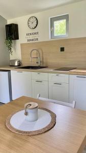 a kitchen with a table and a clock on the wall at Petite maison dans la prairie in Marmeaux