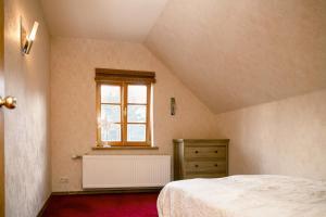 an attic bedroom with a bed and a window at BASH Village House in Ventspils