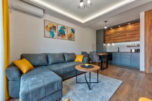 a living room with a blue couch and a table at Contigo Apartman Vrnjacka Banja - Vrnjacka promenada in Vrnjačka Banja