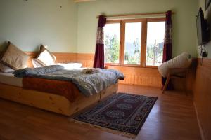 a bedroom with a bed and a window at Kushu Guest House in Leh