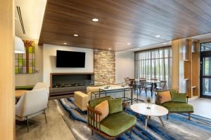 a living room with a fireplace and a tv at Fairfield by Marriott Inn & Suites Rome in Rome