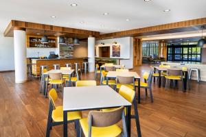 a dining room with tables and yellow chairs at Fairfield by Marriott Inn & Suites Rome in Rome