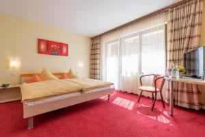 um quarto de hotel com uma cama e uma janela em Hotel Alex em Leukerbad
