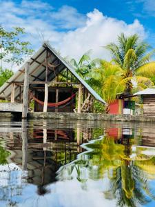 una casa con un reflejo en un cuerpo de agua en Reset, en Zanderij