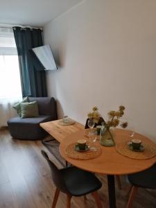 Apartament Kozigród في تكيف: غرفة معيشة مع طاولة وكراسي خشبية