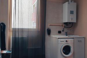 a bathroom with a washing machine and a window at mono polis apartment in Monopoli