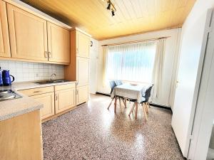 a kitchen with a small table and a window at Friesenhain Ferienwohnungen in Tating +16 photos