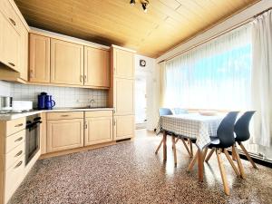 a kitchen with a table and chairs and a window at Friesenhain Ferienwohnungen in Tating