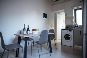 a kitchen with a table with chairs and bottles of wine at Myra city House in Chania Town