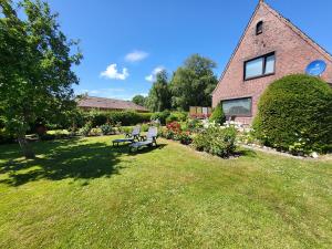 a house with two benches in front of a yard at Friesenhain Ferienwohnungen in Tating