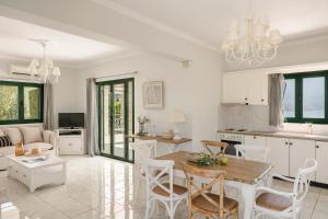 cocina y sala de estar con mesa y sillas en Seaspray Villa Kefaloniaprivatevillas, en Cefalonia