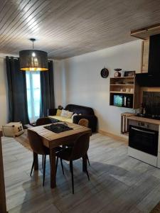 a living room with a table and a kitchen at Appartement Chez Marie et Aymeric in Bages