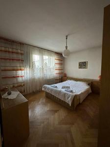 a bedroom with a bed and a large window at Apartment Centar in Prokuplje