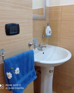 baño con lavabo y toalla azul en Vacanze siciliane, en Fiumefreddo di Sicilia