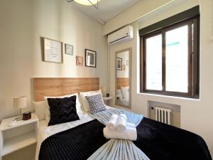 a bedroom with a black and white bed and a window at Exclusivo Terraza Exterior Castellana in Madrid