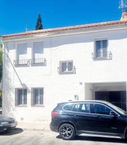 a black car parked in front of a white building at CASA MIGUEL in Puebla de Don Fadrique