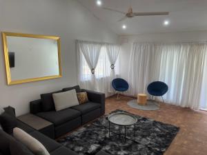 - un salon avec un canapé et deux fauteuils bleus dans l'établissement Villa Le Rosa Unit 3, à Durban