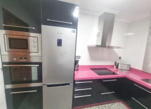 une cuisine avec un réfrigérateur en acier inoxydable et des comptoirs roses dans l'établissement CASA MIGUEL, à Puebla de Don Fadrique