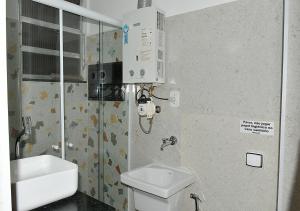 a bathroom with a white toilet and a sink at Studio Miguel Lemos in Rio de Janeiro