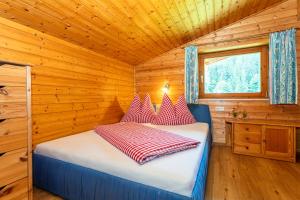ein Schlafzimmer mit einem Bett in einer Holzhütte in der Unterkunft Obertaxinghof in Saalbach-Hinterglemm