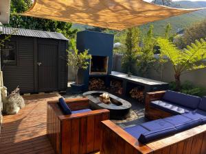 un patio con focolare, divano e sedie. di Seven on Flora- Hot Tub, Modern with amazing outside area a Hermanus