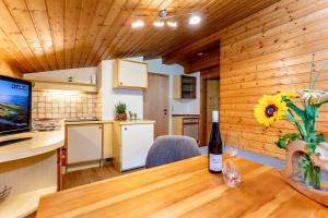 a kitchen and dining room with a table and a bottle of wine at Obertaxinghof in Saalbach-Hinterglemm