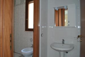 a bathroom with a sink and a toilet and a mirror at Bilocale Giacomo Matteotti in Mazara del Vallo